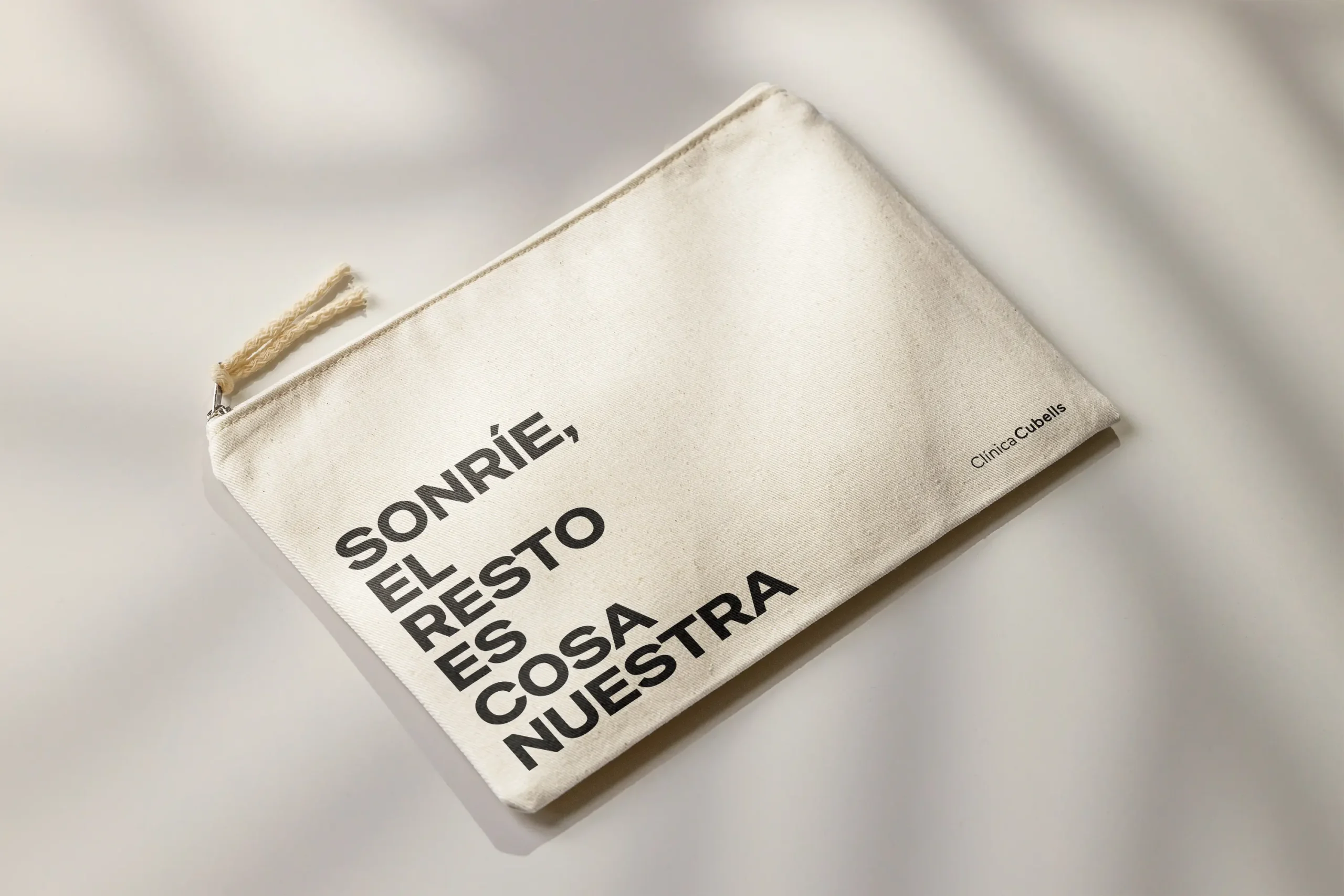 Neceser de tela canvas de Clinica Cubells con el claim sonrie el resto es cosa nuestra fotografiado con luz natural